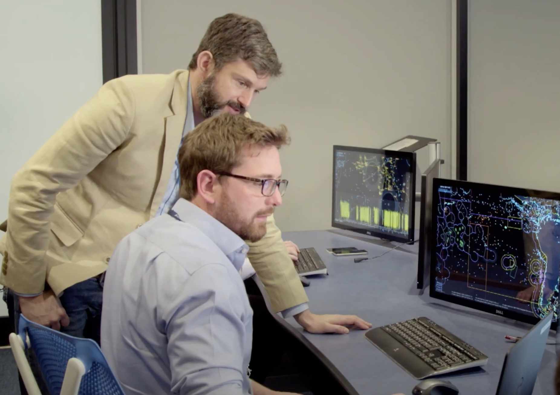 Analysts looking at monitors tracking vessels around the world