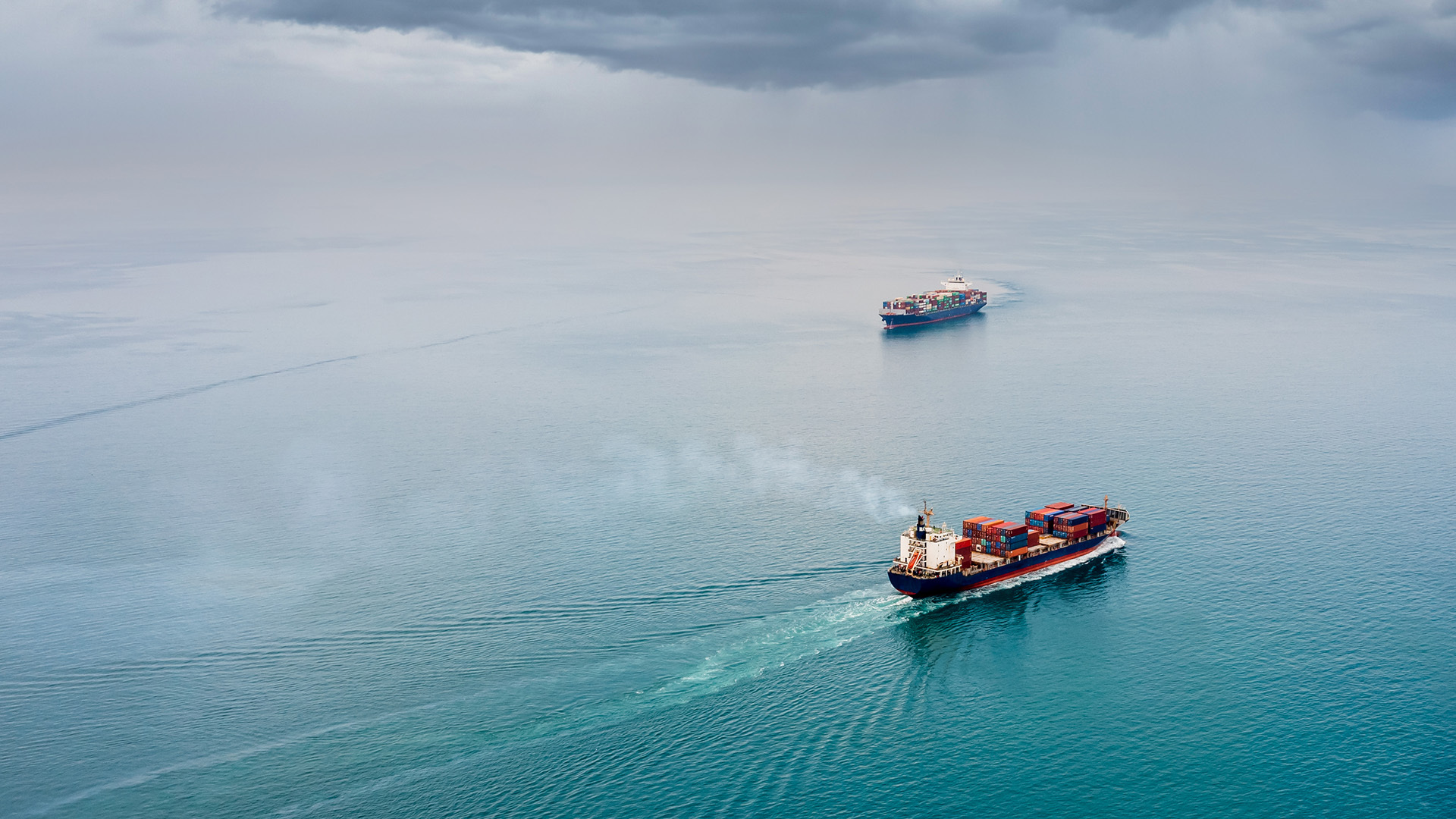 Two container ships cross a calm ocean
