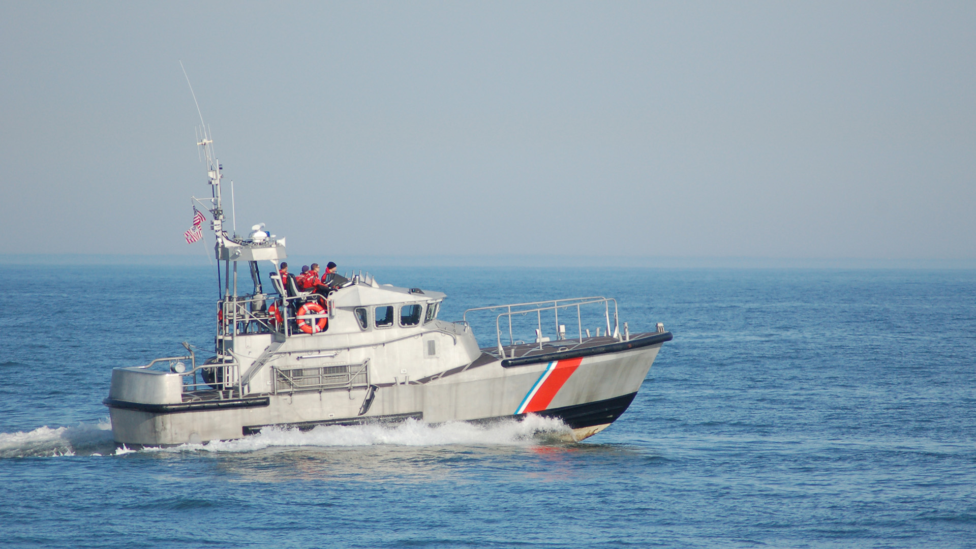 A United States Coast Guard boat and crew speed toward a destination