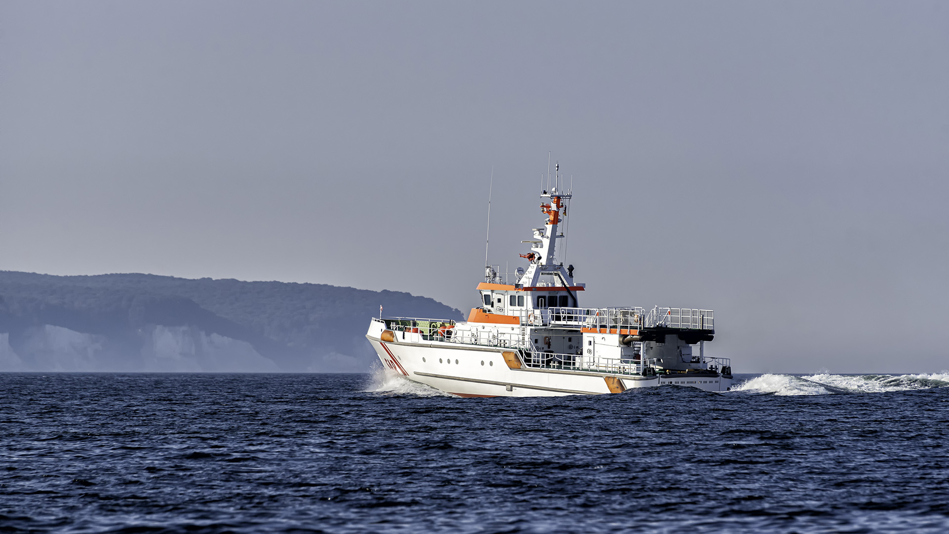 A government boat speeds across the Baltic Sea