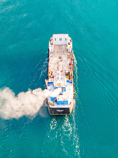 A cruise ship billows white smoke from its stacks